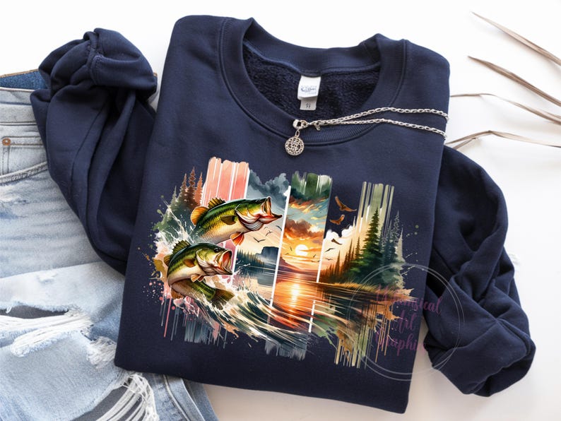 May include: A navy blue sweatshirt with a colorful graphic print of two bass jumping out of the water. The graphic also includes a sunset, trees, and water.
