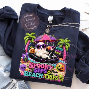 May include: Navy blue sweatshirt featuring a colorful graphic of a ghost on a beach with sunglasses, under an umbrella, and the text "Spooky Sips & Beach Trips." Includes palm trees, pumpkins, and a sign for a "Haunted Beach Club."