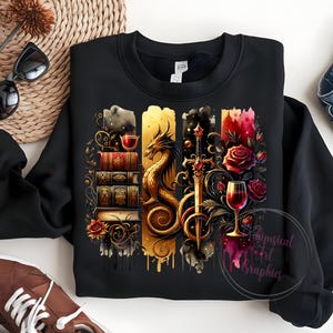 May include: Black sweatshirt with a graphic design featuring a dragon, a sword, a stack of books, and wine glasses. The design is in a watercolor style with gold, red, and black colors.