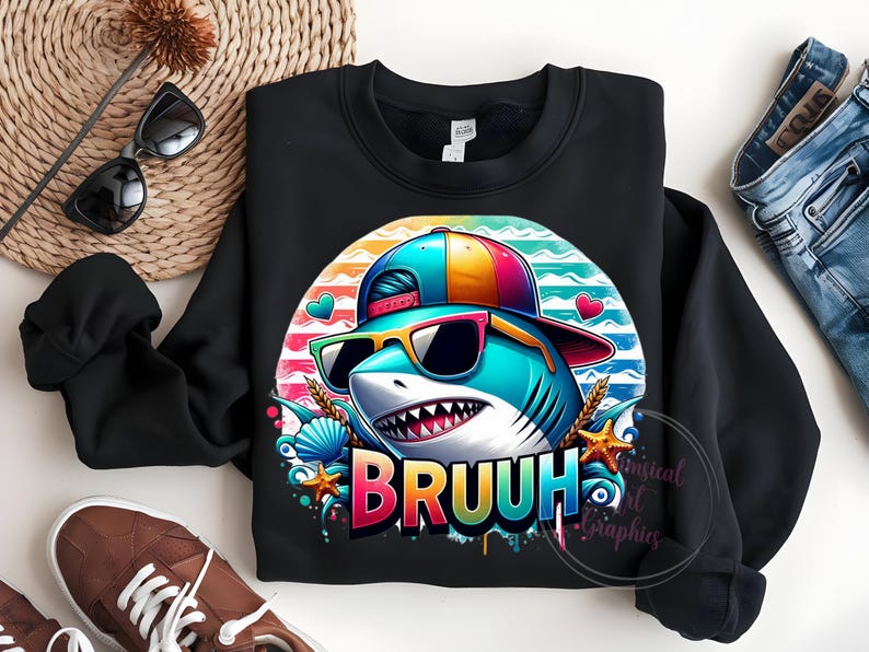 Puede incluir: Sudadera negra con un tibur&oacute;n de dibujos animados con gafas de sol y una gorra. El tibur&oacute;n est&aacute; sobre un fondo a rayas de colores con la palabra "BRUUH" en una fuente vibrante y goteante. El dise&ntilde;o incluye corazones, conchas marinas y estrellas de mar.