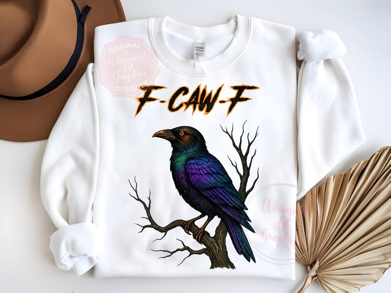 May include: White sweatshirt with a detailed illustration of a crow perched on a branch. The crow has iridescent purple and green feathers. The text "F-CAW-F" is above the crow in a burnt orange font.