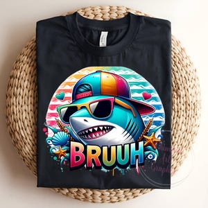 Puede incluir: Camiseta negra con un tibur&oacute;n de dibujos animados que lleva gafas de sol y una gorra colorida. El tibur&oacute;n tiene una gran sonrisa y la palabra "BRUUH" en colores arco&iacute;ris. El dise&ntilde;o incluye corazones, conchas y estrellas de mar.