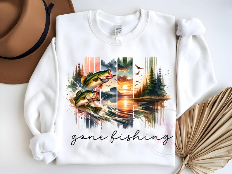 May include: White sweatshirt with a watercolor design of two bass jumping out of the water, a sunset, and trees. The text "gone fishing" is printed below the design.