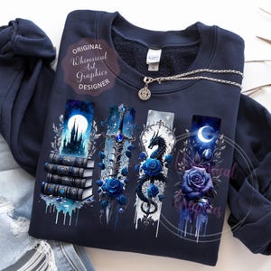 May include: Navy blue sweatshirt with fantasy-themed graphics. The design includes a castle, sword, dragon, and crescent moon, each with blue rose accents. A silver necklace with a pendant is also visible. The text "Original Whimsical Art Graphics Designer" is printed on the sweatshirt.