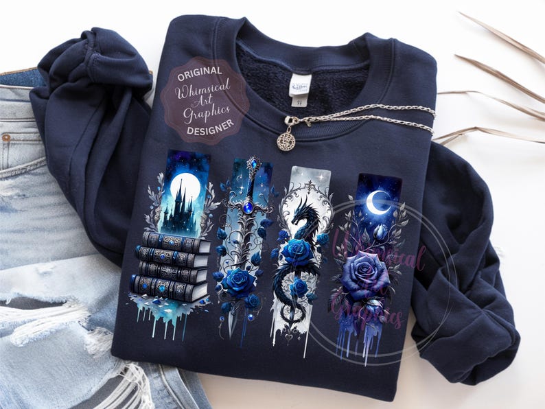 May include: Navy blue sweatshirt with fantasy-themed graphics. The design includes a castle, sword, dragon, and crescent moon, each with blue rose accents. A silver necklace with a pendant is also visible. The text "Original Whimsical Art Graphics Designer" is printed on the sweatshirt.