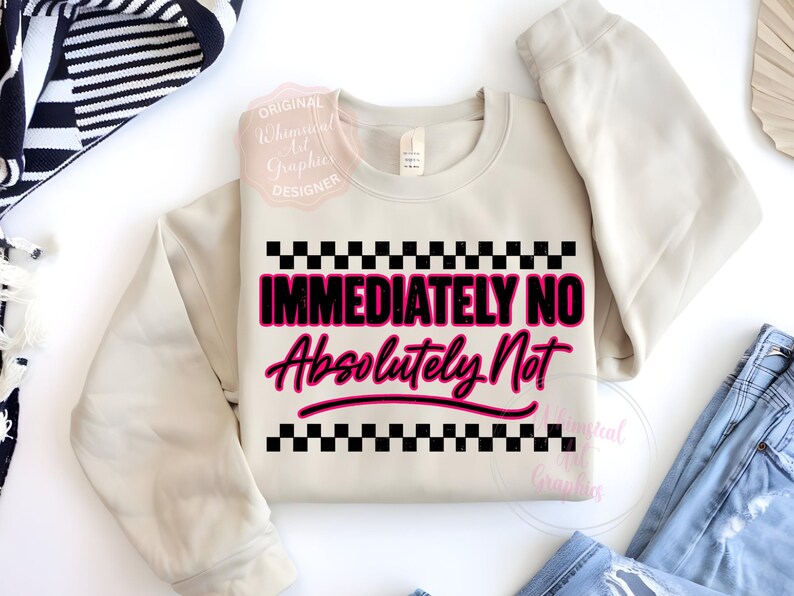 Puede incluir: Sudadera beige de cuello redondo con las palabras "IMMEDIATELY NO Absolutely Not" en un dise&ntilde;o rosa y negro. El texto est&aacute; enmarcado por un patr&oacute;n de cuadros blancos y negros. La sudadera est&aacute; doblada sobre una superficie blanca.