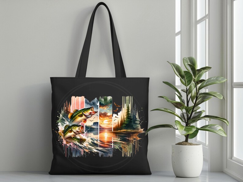 May include: Black tote bag with a colorful watercolor design of two bass jumping out of the water. The design also includes a sunset, trees, and a lake.