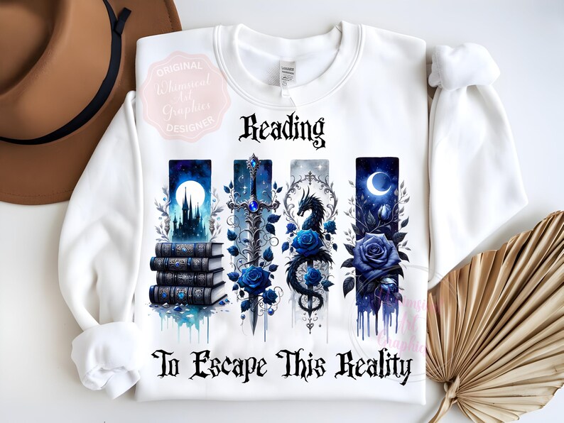 May include: White sweatshirt with a fantasy-themed design. The design includes the word "Reading" above four vertical panels with images of a castle, sword, dragon, and rose. The text "To Escape This Reality" is below the panels.