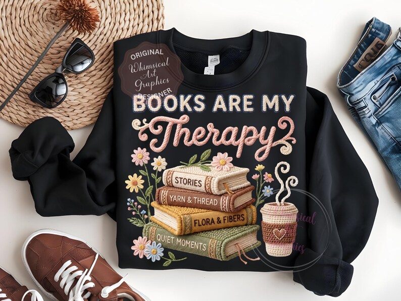 May include: Black sweatshirt with the text "BOOKS ARE MY Therapy" and a stack of books with floral embroidery. The books are labeled "STORIES", "YARN & THREAD", "FLORA & FIBERS", and "QUIET MOMENTS". A coffee cup is also featured.