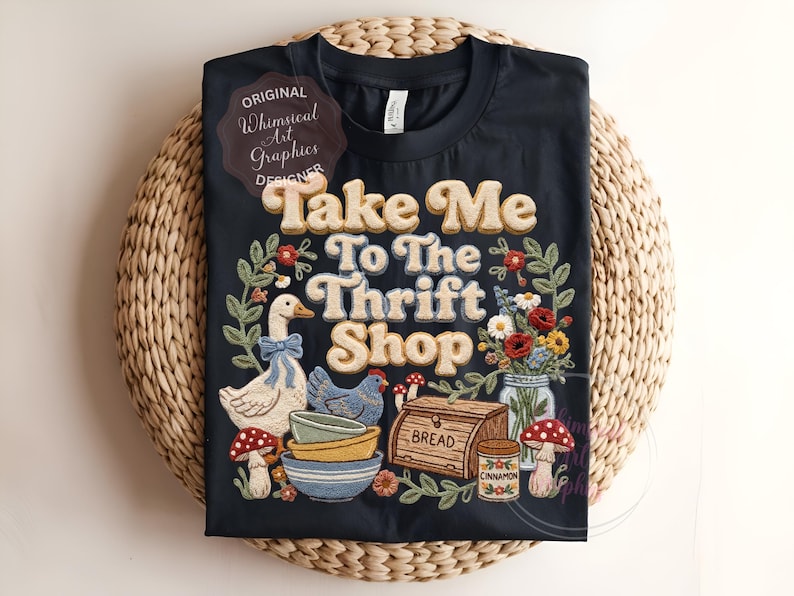 Puede incluir: Camiseta negra con la frase "Take Me To The Thrift Shop" en una fuente retro, rodeada de ilustraciones de un ganso, una gallina, setas, flores y cuencos. La camiseta tiene una est&eacute;tica caprichosa y vintage.