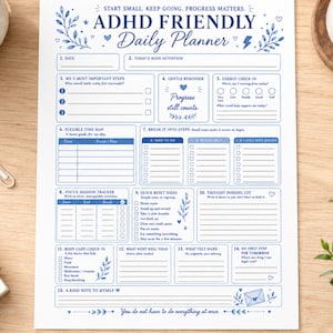 May include: A white daily planner sheet with blue text and botanical illustrations. The header reads ADHD Friendly Daily Planner. Sections include date, main intention, steps, energy check-in, time map, task lists, focus tracker, and self-care notes.