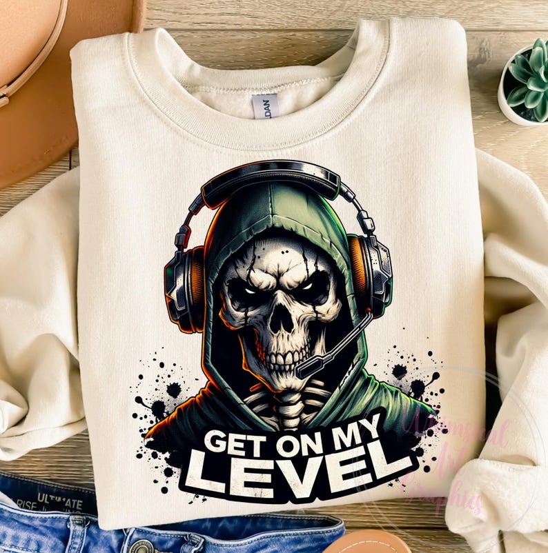 May include: A white sweatshirt with a graphic of a skeleton wearing a green hooded sweatshirt and headphones. The skeleton has a skull with a menacing expression and the text "GET ON MY LEVEL" is printed below the graphic.