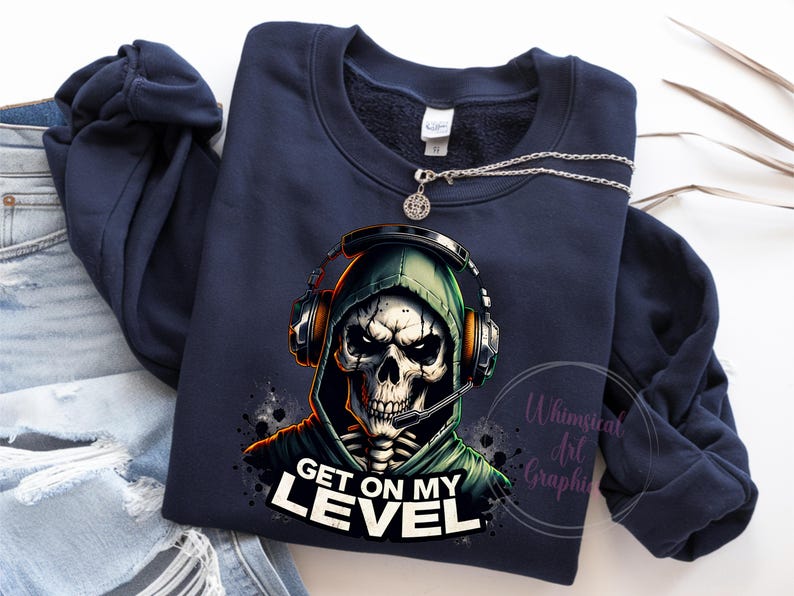 May include: A navy blue sweatshirt with a graphic of a skeleton wearing a hooded sweatshirt and headphones. The text "Get on my level" is printed below the graphic.