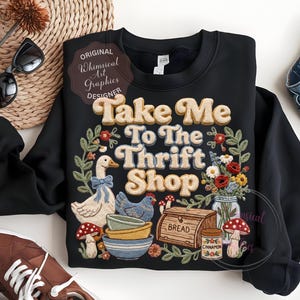 Puede incluir: Sudadera negra con el texto "Take Me To The Thrift Shop" en un estilo retro. El dise&ntilde;o incluye un ganso, una gallina, cuencos, pan, flores y setas. La sudadera tiene cuello redondo y mangas largas.