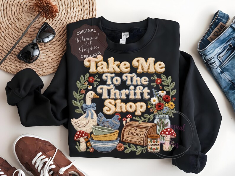 Puede incluir: Sudadera negra con el texto "Take Me To The Thrift Shop" en un estilo retro. El dise&ntilde;o incluye un ganso, una gallina, cuencos, pan, flores y setas. La sudadera tiene cuello redondo y mangas largas.