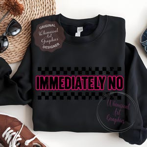 Puede incluir: Sudadera negra con la frase "IMMEDIATELY NO" en rosa brillante, contorneada en negro, sobre un patr&oacute;n de cuadros negros y grises. La sudadera tiene cuello redondo y mangas largas. Gafas de sol y zapatos marrones son visibles.