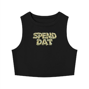 May include: Black crop top with the text "SPEND DAT" in a 3D font made of stacked dollar bills. The top has a rounded neckline and armholes.