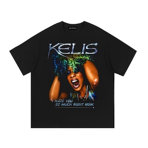 May include: A black short-sleeve t-shirt featuring a graphic print of a person with curly hair and an open mouth. The text KELIS appears in a metallic font above, and the text I HATE YOU SO MUCH RIGHT NOW is printed in white below the graphic.