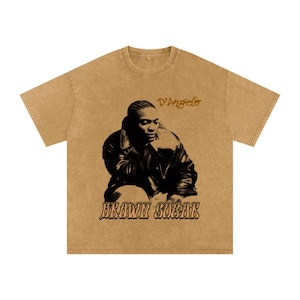 Può includere: T-shirt color senape con un'immagine in bianco e nero di D'Angelo. Il testo "D'Angelo" è sopra l'immagine e "BROWN SUGAR" sotto. La maglietta ha un girocollo e maniche corte.