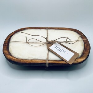 May include: A wooden bread bowl with a white candle inside. The bowl is tied with twine and a brown paper tag that says "Artisan Bread".