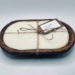 May include: A white candle in a wooden dough bowl with a brown tag that says "Artisan Bread". The candle is tied with twine.