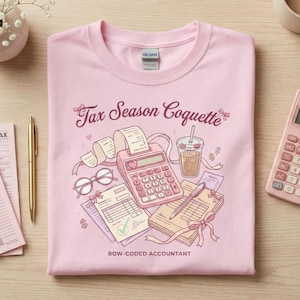 Può includere: Una maglietta rosa chiaro con la scritta "Tax Season Coquette" e "Bow-Coded Accountant". La grafica presenta una calcolatrice, ricevute, occhiali e una bevanda. Una calcolatrice rosa è a destra.