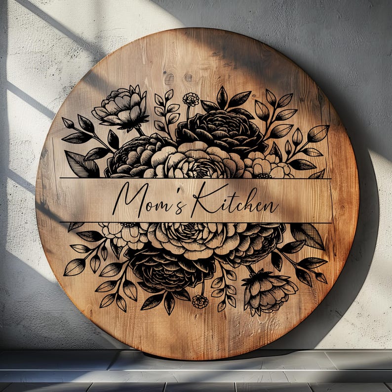 May include: A round wooden sign with a black floral design and the text "Mom's Kitchen" in a banner.
