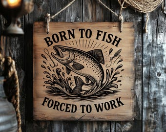 Puede incluir: Un letrero de madera cuadrado colgado de una cuerda, con un gráfico negro de un pez saltando rodeado de salpicaduras de agua y anzuelos. El texto BORN TO FISH está impreso sobre el pez y FORCED TO WORK está impreso debajo del pez.