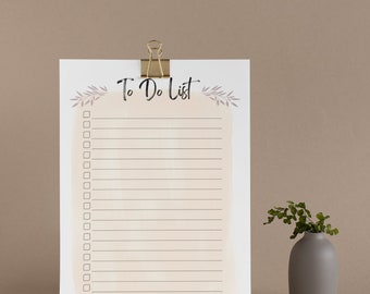 May include: A white to-do list with a gold binder clip at the top. The list has a light brown watercolor background and the words "To Do List" written in black. There are 18 blank checkboxes on the list.