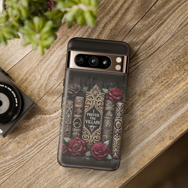 Dark romance phone case with gothic book stack artwork and red roses, featuring “I Prefer the Villain” villain reader design
