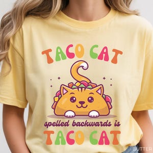 Cute taco cat shirt displayed on butter yellow Comfort Colors tee featuring colorful palindrome phrase and adorable taco cat graphic for cat lovers and quirky humor fans.