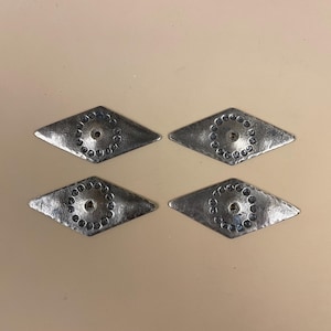 May include: Four diamond-shaped metal plates with a hammered, textured finish. Each plate features a central circular hole surrounded by a ring of small, indented circular impressions, creating a decorative pattern on the silver-toned surface.