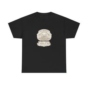 May include: Black t-shirt with a beige graphic. The graphic features the word "MILLWRIGHT" above a detailed emblem and the text "WE DON'T GUESS WE MAKE IT RUN UNDER PRESSURE."