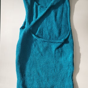 Teal, asymmetrical crop top displayed against white background
