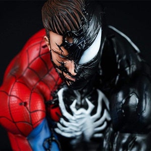 K&ouml;nnte beinhalten: Nahaufnahme einer schwarzen und roten Superheldenfigur. Die Figur ist eine Kombination aus Spider-Man und Venom, wobei Venoms Gesicht die H&auml;lfte von Spider-Mans Gesicht bedeckt. Die Figur ist detailliert mit komplizierten Spinnweben und Muskeldefinition.