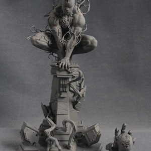 May include: A gray, detailed, 3D printed figurine of a superhero character with a black, organic-looking suit. The figure is posed in a crouching position on a ruined, stone platform. The platform is surrounded by broken pieces of stone and vines. A smaller, separate hand-shaped figurine is also included.