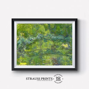 May include: A framed painting of a green landscape with a river and trees. The painting is in a black frame and has a white mat. The painting is titled "Strauss Prints" and has a logo with a paintbrush and palette.