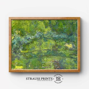 May include: A framed painting of a landscape with a green and blue color scheme. The painting depicts a forest scene with a river or stream running through it. The painting is framed in a light brown wood frame.