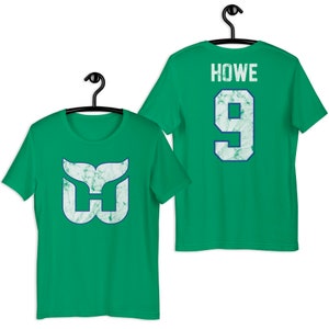 May include: Green t-shirt with a white whale tail logo and the text "HOWE 9" on the back.