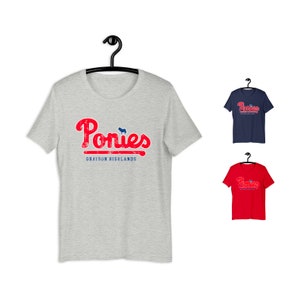 May include: A heather grey t-shirt with a red and blue vintage-style graphic that says "Ponies Grayson Highlands".