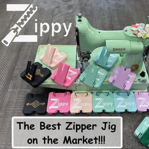 May include: A mint green vintage Singer sewing machine surrounded by multiple Zippy zipper jigs in various colors including black, pink, peach, mint, and lavender. Each jig features the Zippy logo and a vertical stand for holding zippers.