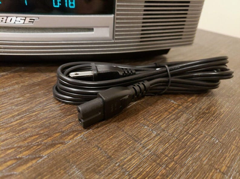 May include: A black electrical cord with a standard three-prong plug on one end and a two-prong plug on the other end.