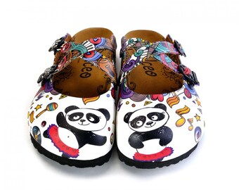 May include: Pair of white clogs with a panda bear design. The clogs feature black soles, brown insoles, and straps with colorful patterns. Each clog has a panda illustration and musical notes.