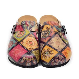 May include: A pair of colorful clogs with a patchwork design. The clogs feature a variety of colors including red, yellow, green, and purple. Each clog has a buckle closure and a cork footbed. The clogs are designed for comfort and style.
