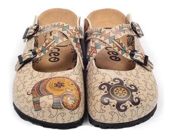 May include: Pair of beige clogs with decorative elephant and turtle designs. The clogs feature a cross-strap design with geometric patterns in orange, teal, and brown. The clogs have black soles and adjustable buckles.