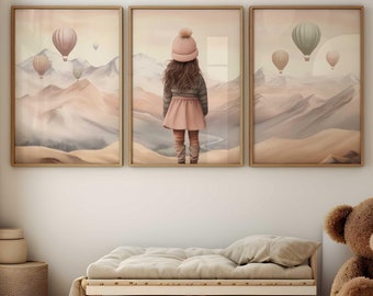 Op de afbeelding: Drie ingelijste kunstdrukken met een kind dat naar heteluchtballonnen boven een bergketen kijkt. De prints zitten in lichtbruine lijsten. De kamer heeft een klein bed, een teddybeer en een rond tapijt.