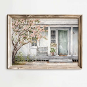 K&ouml;nnte beinhalten: Ein Aquarellbild eines wei&szlig;en Hauses mit einer hellblauen T&uuml;r und einer Veranda mit einer wei&szlig;en Bank. Ein rosa bl&uuml;hender Baum steht im Vorgarten.