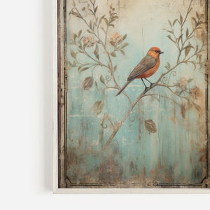 K&ouml;nnte beinhalten: Ein gerahmter Vintage-Druck mit einem kleinen orangefarbenen Vogel, der auf einem Zweig mit zarten wei&szlig;en Bl&uuml;ten sitzt. Der Hintergrund ist ein verblasster blauer und gr&uuml;ner Aquarell-Wasch.