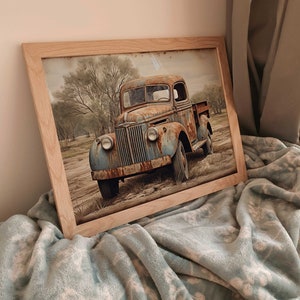 May include: A framed print of a rusty blue pickup truck parked in a field with trees in the background.