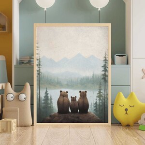 May include: A framed print of a painting depicting three brown bears sitting on a rock overlooking a lake and mountains in the distance. The sky is a light blue with white clouds.